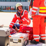 Sanitätsdienst: Einsatzübung von DRK und Feuerwehr auf dem Flughafen von Dresden. Rettungskräfte vom DRK versorgen einen Mann, der auf einer Trage liegt.