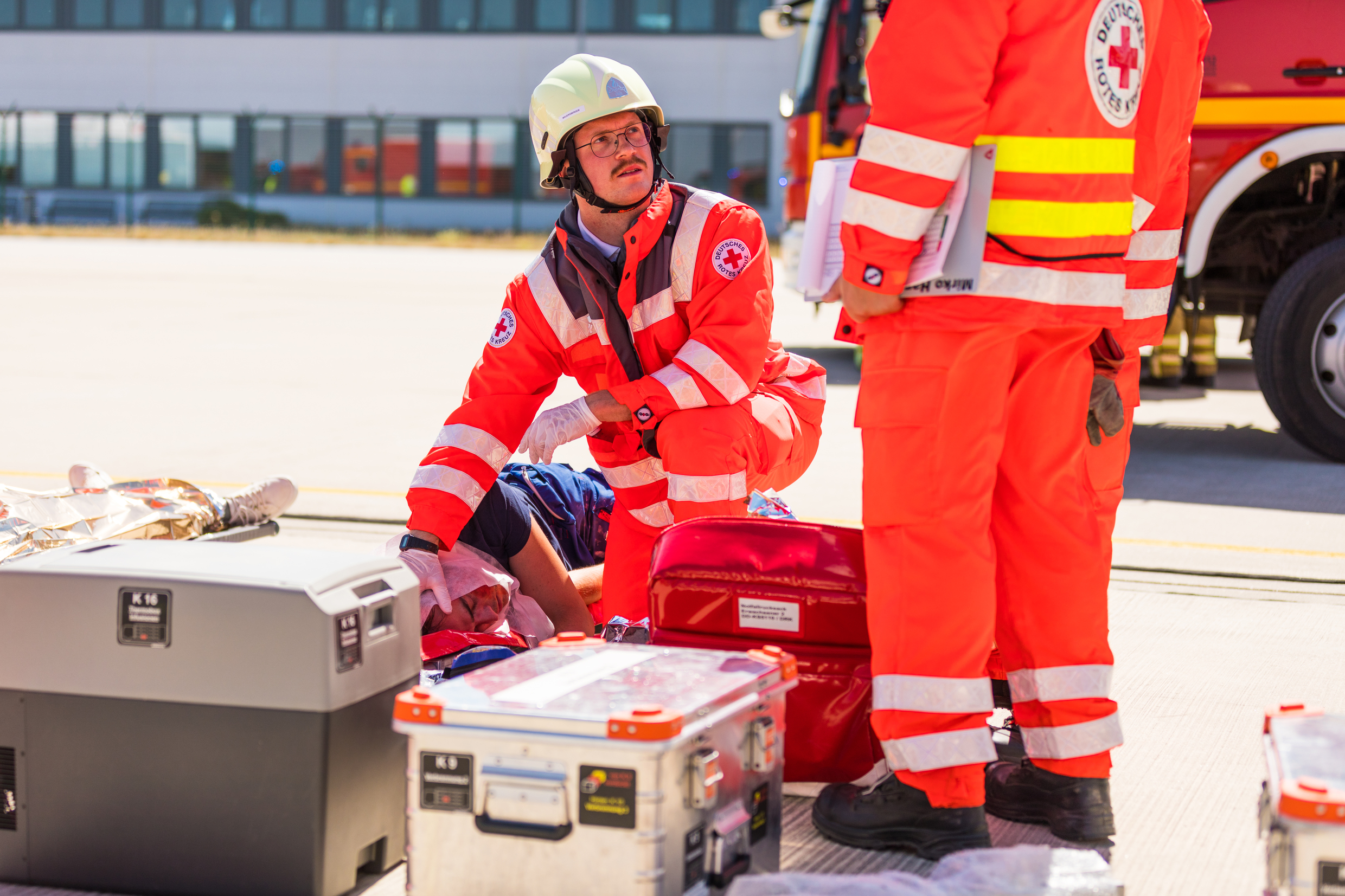 Sanitätsdienst: Einsatzübung von DRK und Feuerwehr auf dem Flughafen von Dresden. Rettungskräfte vom DRK versorgen einen Mann, der auf einer Trage liegt.