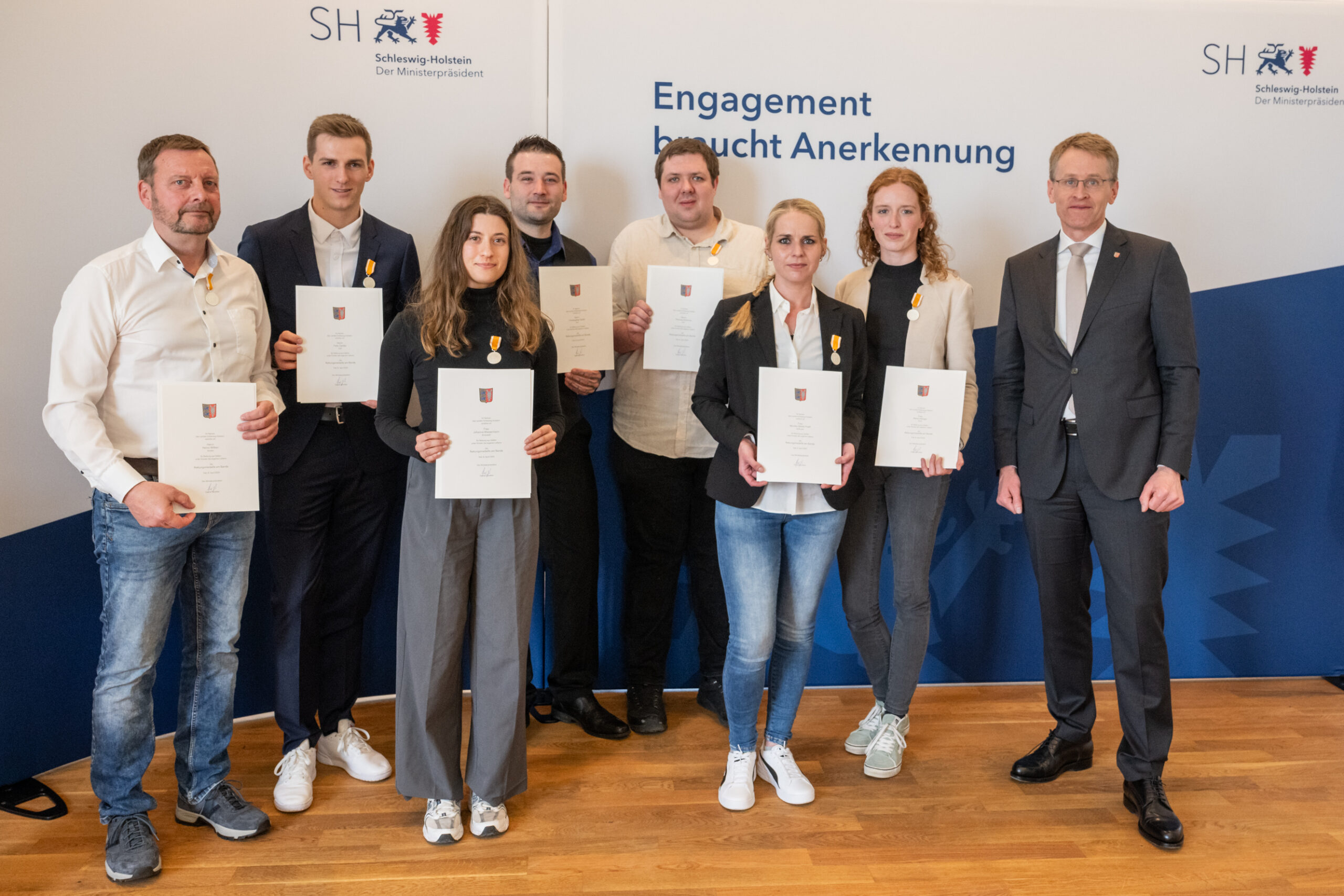 Die mit der Rettungsmedaille Geehrten v.l.: Heino Wilken, Felix Gerike, Johanna Wassermann, Christopher Strahl, Thomas Brömme, Monika Sibilitz-Prieß, Maria Hitziger mit Ministerpräsident Daniel Günther (rechts)